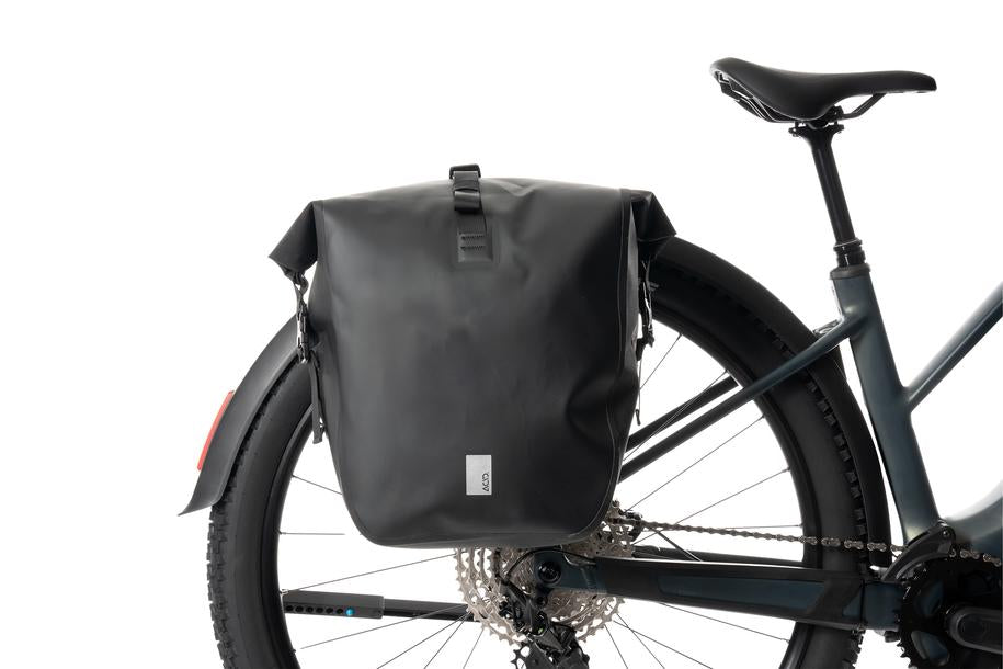 Der ACID Gepäckträger SIC 2.0 RAIL schwarz, eine wasserdichte Gepäckträgertasche von ACID, ist hier mit dem RAIL-Träger-System auf einem Gepäckträger eines Breitreifenfahrrads vor weißem Hintergrund befestigt.
