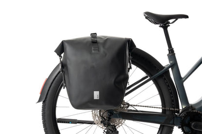 Der ACID Gepäckträger SIC 2.0 RAIL schwarz, eine wasserdichte Gepäckträgertasche von ACID, ist hier mit dem RAIL-Träger-System auf einem Gepäckträger eines Breitreifenfahrrads vor weißem Hintergrund befestigt.
