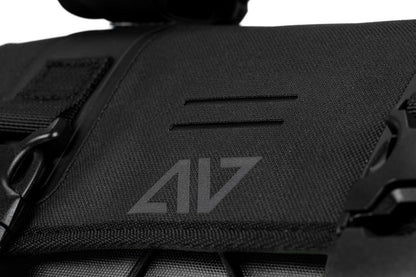 Nahaufnahme der ACID Lenkertasche PACK PRO 15 black von ACID, mit schwarzem Stoff, sichtbarem Reißverschluss, Kunststoffclip und markantem Logo. Die Textur und die Nähte unterstreichen das hochwertige Design, das von der niedersächsischen Handwerkskunst inspiriert ist.