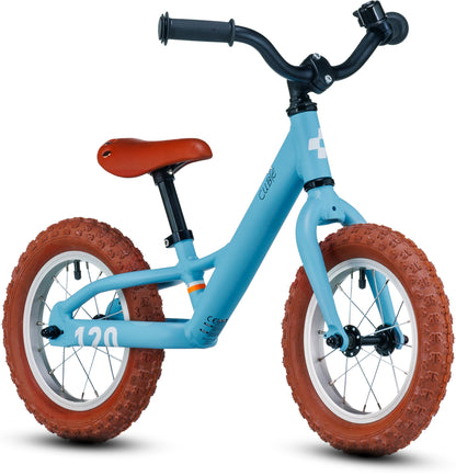 Das Cube CUBE Cubie 120 walk light blue'n'white Laufrad ist ein Balance-Fahrrad mit einem stabilen Rahmen und ohne Pedale, das für kleine Kinder, die das Fahren lernen, entwickelt wurde. Es hat braune Reifen und einen braunen Sattel.