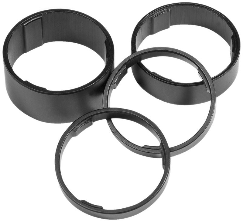 Vier schwarze RFR Spacer aus Kunststoff in verschiedenen Größen sind auf weißem Hintergrund angeordnet. Die RFR Spacer Set 1 1/8 eignen sich ideal als Gabelschaft Adapter oder Aluminium Spacer.