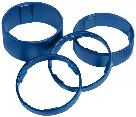 Vier blaue, kreisförmige RFR-Abstandshalter-Set 1 1/8 Aluminiumringe mit kleinen nach innen gerichteten Laschen sind auf einem weißen Hintergrund angeordnet. Zwei RFR-Abstandshalter stehen aufrecht und zwei liegen flach, leicht überlappend.