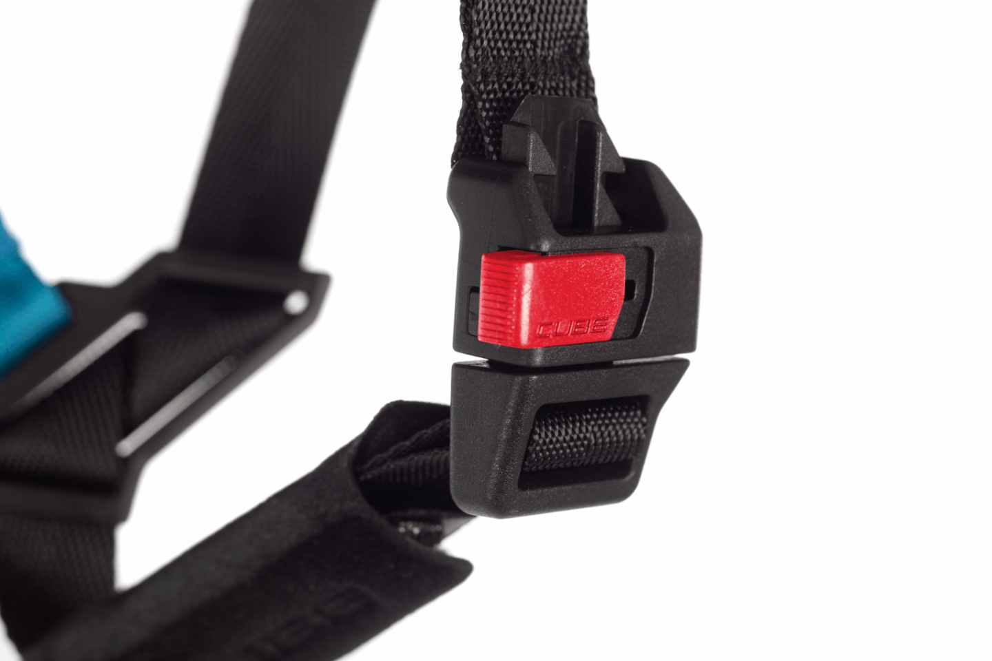 Nahaufnahme einer schwarzen Kunststoffschließe mit rotem Knopf an einem schwarzen Armband, Teil des CUBE TALOK - Kinderhelms von Cube, vor einem weißen Hintergrund.
