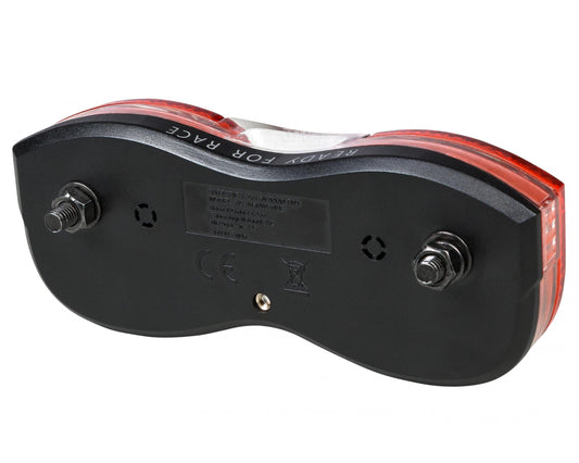 Das Bild zeigt die Unterseite des RFR Gepäckträgerrücklichts STANDARD Batterie Rücklicht (80 mm Abstand) in schwarz und rot, mit zwei freiliegenden Befestigungsschrauben, einem zentralen Etikett und "READY FOR RACE", das in den klaren Kunststoff eingegossen ist.