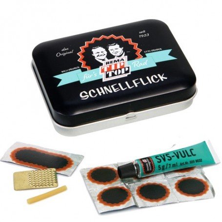 Das Tip Top TT02 Schlauch-Reparaturset Nostalgie Flickzeug von Tip Top kommt in einer nostalgischen Blechdose, inklusive Klebeschlauch, Gummiflicken, Metallraspel und gelbem Stift - perfekt für die stilvolle und zuverlässige Reparatur von Fahrradreifen.