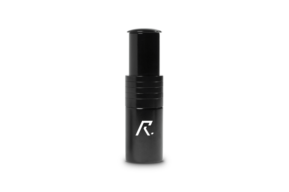 Eine schwarze, zylindrische RFR Steuerrohrverlängerung (28,6 mm x 67 mm) aus Aluminium 6061 mit erhöhter Kappe und weißem, stilisiertem RFR-Logo auf der Vorderseite wird vor einem schlichten weißen Hintergrund präsentiert.